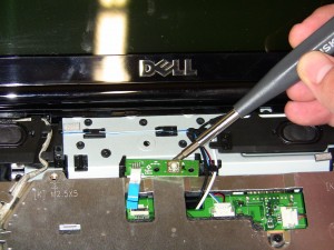 Unhook the 1545 power button board cable by lifting the latch on the motherboard connector. 