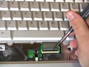 Lift the keyboard cable connector latch and remove the keyboard ribbon cable and keyboard. 