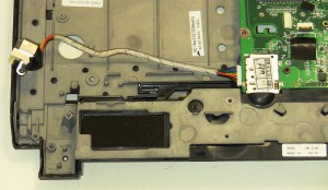 Remove the cable from the routing and unplug the DC jack from the motherboard. 