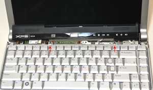 Unscrew the (2) 2mm x 2mm x 7mm wafer screws holding the keyboard to the base and gently flip the keyboard over. Be cautious, lifting the keyboard with the cable connected, it is possible to break the latch if you pull it too hard. 