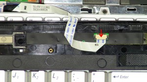 Turn the power button cover over to expose the ribbon cable and unplug it. 
