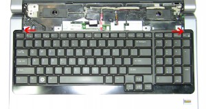 Starting at the top edges of the keyboard bezel, carefully lift it up and unsnap it working your way around the keyboard.