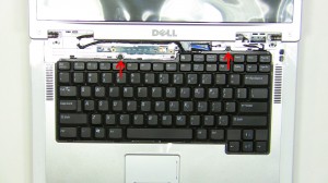 Carefully lift the keyboard up and place it onto the LCD screen to reveal the keyboard cable connection.