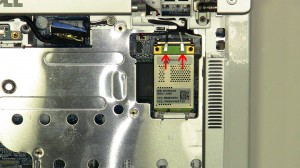 Press the wireless card latch up until the card pivots up at a 45 degree angle. 