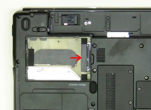 Using the black tape, lift the hard drive and caddy out of the laptop. 