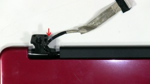 Loosen the LCD cable from the routing channels on the left hinge.