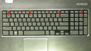 Using a flathead screwdriver or plastic scribe, press in the 4 latches to release the keyboard. 