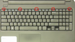 Using a plastic scribe or flat head screwdriver, press in the keyboard latches at the top of the keyboard.