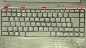 Press the keyboard tabs in to loosen the keyboard.