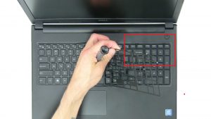 Use plastic scribe to release tabs and remove keyboard bezel.