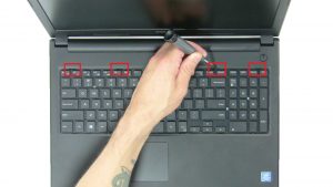 Use plastic scribe to turn over keyboard.