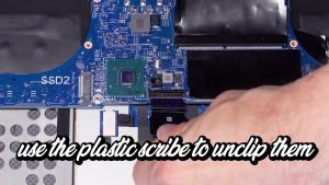 Disconnect the motherboard cables. Use a plastic scribe to unclip them where shown.