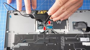 Unlatch the touchpad cable clips in the direction indicated.