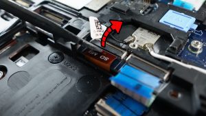 Unclip the locking tab to unlatch and disconnect the SD Card Reader cable.